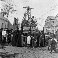 2. JUAN JOSÉ SERRANO GÓMEZ. Paso de misterio del Cristo de las Cinco Llagas de la Hermandad de la Trinidad por la antigua calle Arrebolera. 1917 El paso aún no había incorporado las figuras de los Santos Varones, Nicodemo y José de Arimatea. A la derecha, en la actual calle María Auxiliadora, la fábrica de Gallardo y Núñez (envases de hoja de lata), ejemplo de la arquitectura industrial de la época. © ICAS-SAHP, Fototeca Municipal de Sevilla, Archivo Serrano