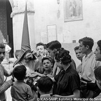 22. ÁNGEL GÓMEZ BEADES GELÁN. Revuelo en la plaza de San Román. Década de 1960.  Antes de la salida, un nazareno de la Hermandad de la Exaltación reparte caramelos la tarde del Jueves Santo. © ICAS-SAHP, Fototeca Municipal de Sevilla, Archivo Gelán