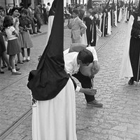 28. JUAN JOSÉ SERRANO GÓMEZ. La Hermandad del Cachorro por la calle Castilla. 1961.   La figura del hombre del cántaro palía el sofoco de la primavera sevillana en esta calle trianera.   © ICAS-SAHP, Fototeca Municipal de Sevilla, Archivo Serrano