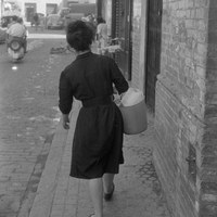 Señora transportando una barra de hielo en un cubo para la conservación de alimentos en las antiguas fresqueras. 1960-1965 ©ICAS-SAHP, Fototeca Municipal de Sevilla, fondo Serrano