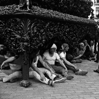 29. JUAN JOSÉ SERRANO GÓMEZ. Un descanso entre chicotás. 1966.  Los hombres del costal descansan bajo la impresionante canastilla neobarroca barnizada en caoba de la Hermandad de la Carretería. Con la irrupción de los hermanos costaleros en 1973 la profesionalidad tiende a desaparecer. La primera cuadrilla no profesional fue la del paso del Cristo de la Buena Muerte de los Estudiantes, mandada por Salvador Dorado “El Penitente”.  © ICAS-SAHP, Fototeca Municipal de Sevilla, Archivo Serrano