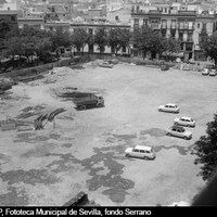 Una vez trasladado el mercado a un solar próximo y ante la tardanza para acometer un proyecto definitivo, la parcela de la plaza de abastos se convertiría en zona de aparcamiento público desde 1973 a 2004. 1975 ©ICAS-SAHP, Fototeca Municipal de Sevilla, fondo Serrano